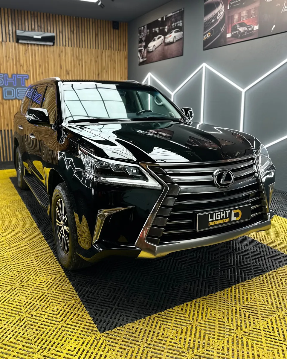 Чёрный Lexus LX в боксе студии под гекса-светом